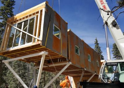 The end building module is placed with the assistance of a crane. Note: the glass doors were installed before the module was shipped. All building modules were complete except for their interior finish.